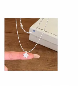 Detailed macro view of zircon star pendant necklace with layered silver pearl chain