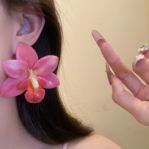 Dettaglio dell'orecchino a forma di orchidea rosa in resina con ago in argento 925.