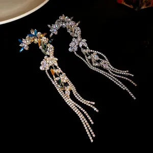Detailed view of glittering crystal flower ear cuffs with long rhinestone tassels