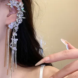 Detail showing a sparkling zircon flower ear cuff with elegant and long dangling tassels