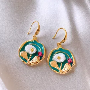 Detailed view of elegant floral enamel earrings featuring pearl flower and gold plating
