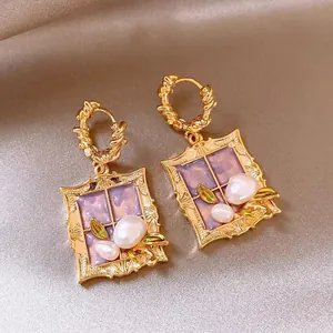 Close-up of Monet's Garden themed earrings with purple resin inlay and white pearls
