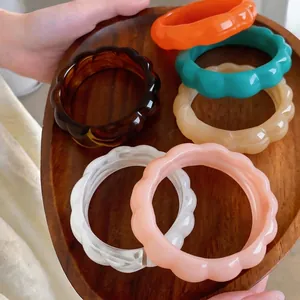 Set di bracciali retrò in acrilico colorato con bordi geometrici ondulati su vassoio