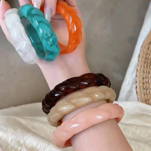 Set di bracciali a spirale in acrilico retrò in vari colori sul polso di una modella