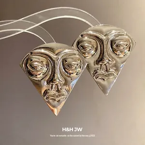 Vintage exaggerated human face studs in silver-toned metal for a bold fashion statement