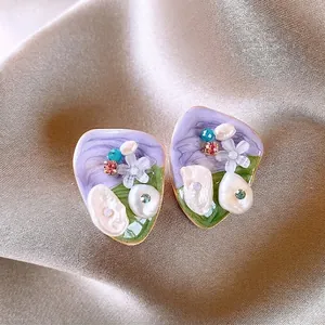 Macro view of Monet Garden style pearl earrings with colorful crystals on satin background