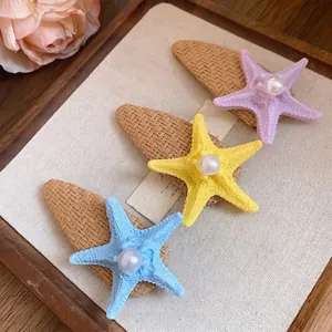 Starfish hair clips with raffia base and pearl accents for summer beach vacation styling.