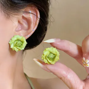 Primo piano di orecchini a rosa verde chiaro placcati in oro 18 carati con trama petalo.