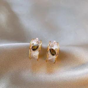 Detailed view of Monet's Garden style earrings with olive green teardrop gemstones.