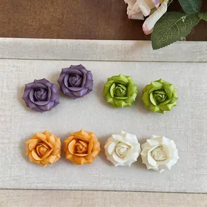 Dettaglio di orecchini a rosa placcati oro 18 carati in viola, verde, arancione e bianco.