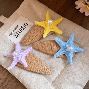 Sea island raffia starfish hair clips with pearl detail in yellow blue and purple