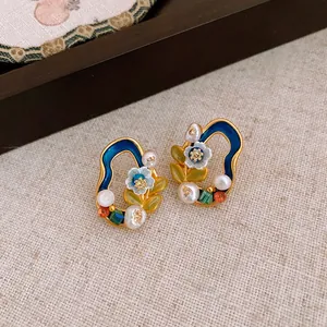Detailed macro shot of vintage Monet garden style stud earrings with enamel and pearls