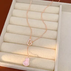 Rose gold necklace with pink zircon gourd pendants displayed in a jewelry tray