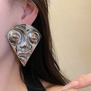 Close-up of retro abstract silver face stud earring with polished mirror finish