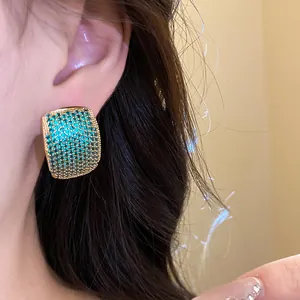 Detailed close-up shot of vintage style emerald green pavé zircon stud earrings on model