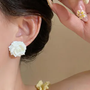 Vista dettagliata di eleganti orecchini a forma di camelia bianca placcati in oro 18K