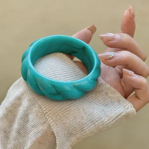 Vista dettagliata di un bracciale vintage in acrilico turchese con design a spirale