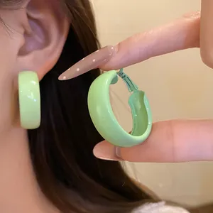 Detail showing a mint green painted hoop earring and its sturdy clasp mechanism