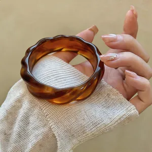 Primo piano di un bracciale vintage stile in acrilico ambrato con eleganti bordi ondulati