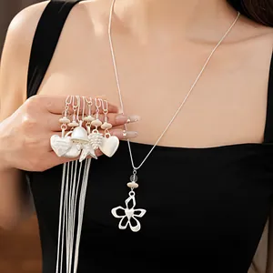 Close-up detail of elegant silver necklaces with heart, flower and star shaped charms