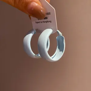 Close-up of light blue spray-painted round hoop earrings with glossy finish