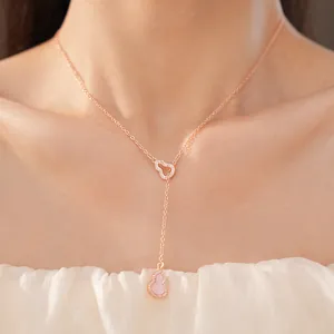 Close-up of rose gold Y-shaped necklace featuring pink gourd pendant with zircon stones