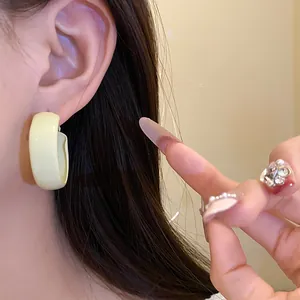 Chic yellow C-shaped hoop earrings with a smooth matte finish for a fresh, elegant look