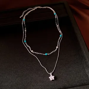 Elegant double-layered necklace with blue beads, pearls, and a zircon star pendant