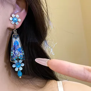 Detail of vintage blue resin flower clip-on earrings with rhinestones and palace style