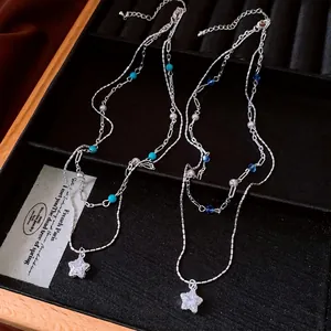 Double-layered silver necklace with star pendant, blue beads, and white pearls
