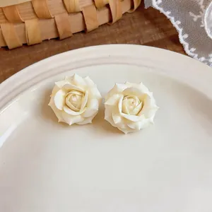 Eleganti orecchini a forma di rosa color crema placcati in oro 18 carati in primo piano