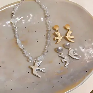 Elegant swallow pendant necklace and earring jewelry set with matte gold and silver finish