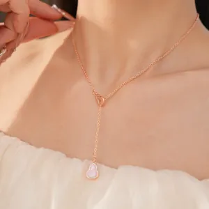 Detail shot of an elegant pink zircon hollow gourd pendant necklace worn on the neck