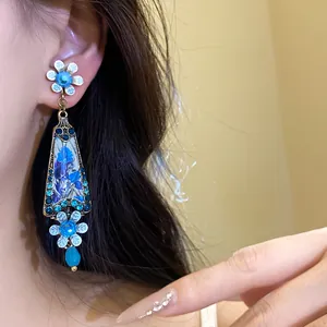 Detail shot of vintage palace style earrings with blue resin flowers and rhinestones