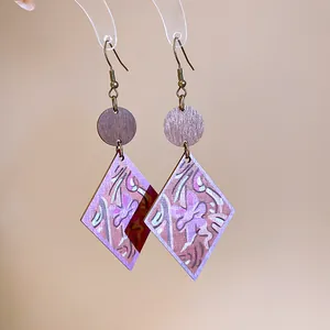 Close-up detail of Bohemian style wooden earrings featuring diamond-shaped printed pendants