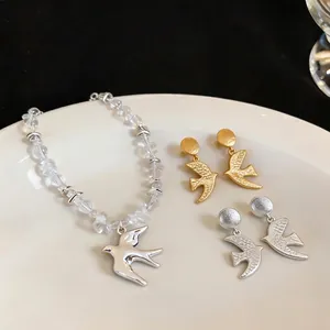 Elegant matte swallow jewelry set featuring silver pendant necklace and gold stud earrings