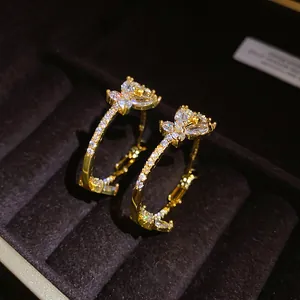 Close-up of gold-plated butterfly hoop earrings with sparkling cubic zirconia stones