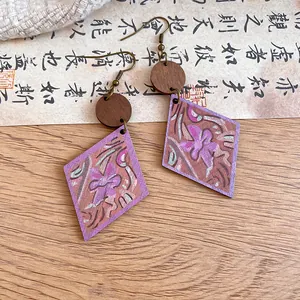 Detail of bohemian wooden earrings with purple floral print and rhombus drop shape.