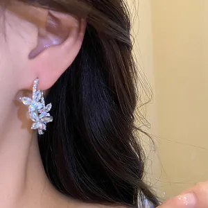 Detail view of an elegant 18k gold plated butterfly hoop earring with shiny zircons.