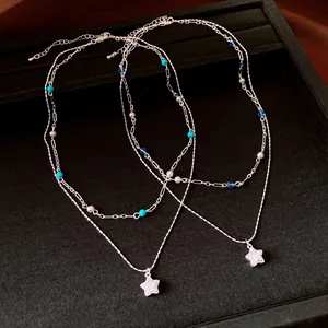 Close-up of double-layer necklace with cubic zirconia stars and blue beads on a tray