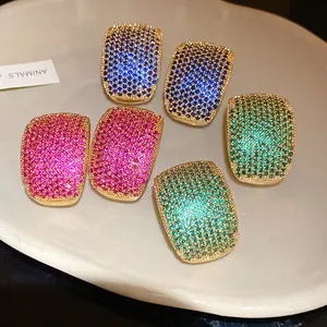 Detailed close-up of vintage gold-toned stud earrings with colorful pavé set zircons