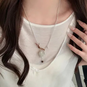 Close-up of elegant silver heart necklace with bow detail on female model wearing white
