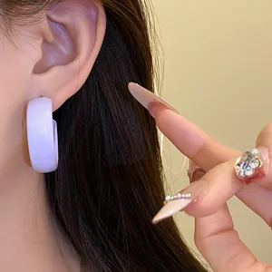 Macro detail of a high-quality glossy lavender spray-painted hoop earring on ear