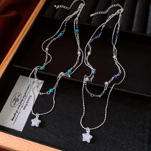 Detailed macro view of a double-layered necklace with zircon star and pearl beads