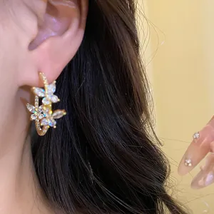 Close-up of elegant 18k gold plated butterfly hoop earrings adorned with sparkling zircons