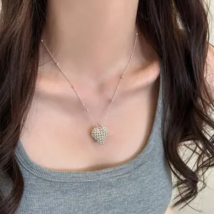 Elegant close-up of a textured silver heart pendant necklace worn by a woman for daily styling