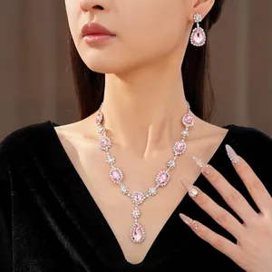 Elegant pink rhinestone teardrop jewelry set including necklace and earrings on model.