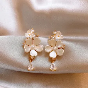 Detailed macro view of elegant floral earrings featuring a shimmering teardrop zircon drop