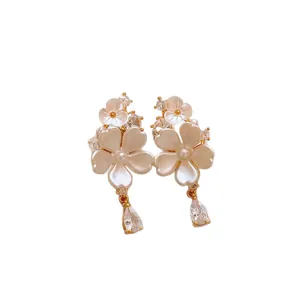 Elegant flower earrings with teardrop zircon dangles and pearl accents on white background