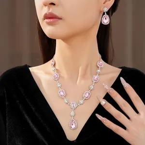 Detailed view of elegant pink teardrop rhinestone necklace and earring jewelry set on model